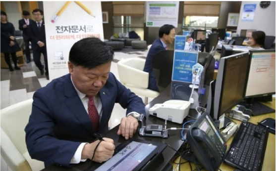 NH-investment-and-securities 1-1 Customer signing on tablet at a bank branch